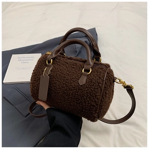 Detail of plush lambskin texture on brown Boston bag with smooth leather handles