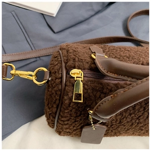 Detail der dunkelbraunen Boston-Tasche aus Teddy-Fleece mit Lederriemen und Gold-Hardware