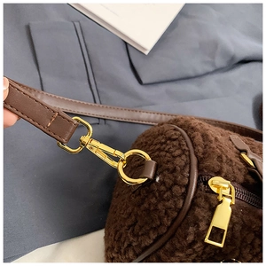 Detail der Boston-Tasche aus Plüsch mit goldenen Beschlägen und braunem Lederriemen