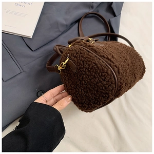 Detailansicht der dunkelbraunen Lammfell-Tasche mit Lederbesatz und goldenem Verschluss