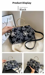 Détail d'un sac à main coquille vintage avec broderie florale noire et fermoir doré