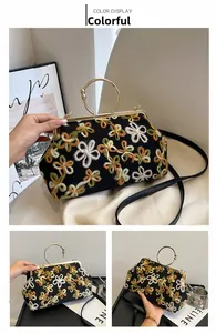 Gros plan sur la broderie florale et la poignée en métal doré du sac de soirée
