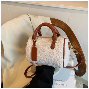 Detail of plush faux shearling Boston bag featuring brown leather trim and golden hardware