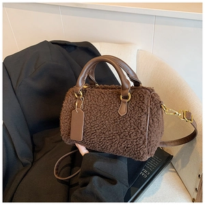 Detail of brown teddy fleece Boston bag with leather handles and gold-tone hardware