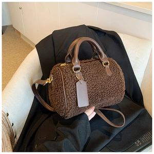 Detailed view of dark brown plush Boston bag with leather handles and gold-tone hardware