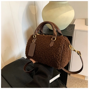 Detailansicht der braunen Teddy-Boston-Tasche mit Fokus auf Textur und Goldbeschläge