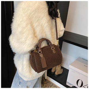 Brown faux fur Boston bag with leather handles and crossbody strap worn by a model