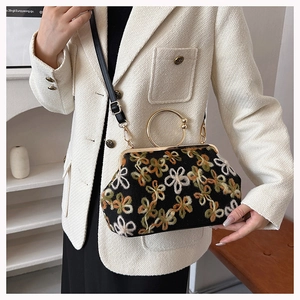 Détail du sac brodé à fleurs avec poignée ronde dorée et fermoir métallique vintage