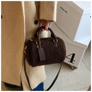 Detail der braunen Boston-Tasche aus Plüsch mit Ledergriffen und goldenen Akzenten