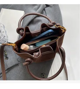 Internal view of brown leather bucket bag showing compartments for phone and cosmetics
