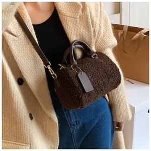 Detailansicht der dunkelbraunen Teddy-Plüsch Boston Tasche mit goldenen Beschlägen