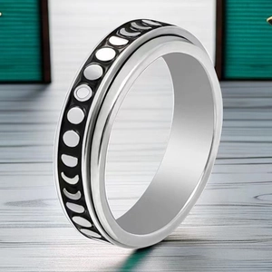 Macro view of rotating stainless steel ring band featuring moon phase engraving details
