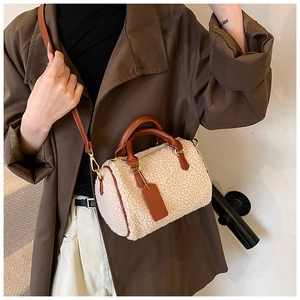 Detail of plush off-white fleece Boston bag with brown leather handles and gold hardware