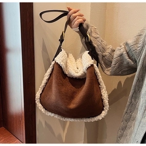 Détail d'un sac cabas en daim marron avec bordure en peau lainée et sangle en cuir