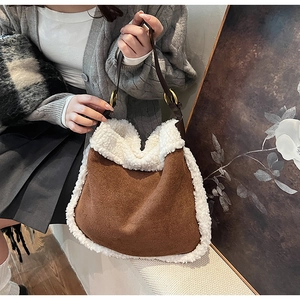 Détail du sac fourre-tout en daim marron avec bordure en peau lainée et boucle dorée