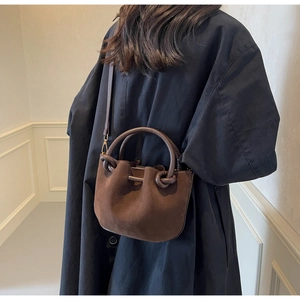 Detail of vintage matte brown bucket bag with unique knotted handles and gold hardware
