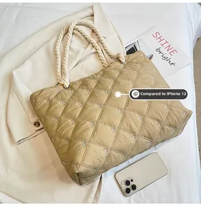 Quilted canvas tote with bow embroidery and size comparison with iPhone 12