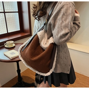 Détail du sac seau en daim d'hiver avec bordure en laine d'agneau et bandoulière en cuir