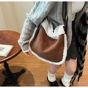 Détail du sac sous le bras en daim marron avec bordure en peau de mouton synthétique