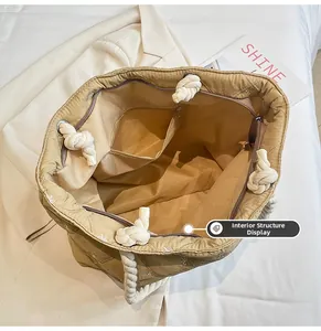 Quilted tote bag interior view featuring main compartment and zippered security pocket