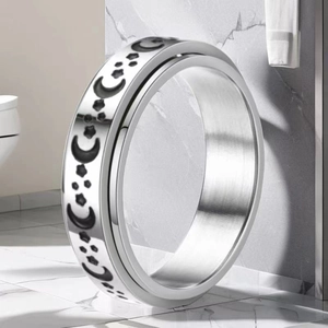 Detail of spinning stainless steel ring featuring celestial moon and star engravings