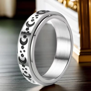 Macro shot of polished silver spinner ring featuring engraved moon and star patterns