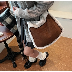 Détail du sac cabas en suédine marron avec bordure en peluche blanche et bandoulière