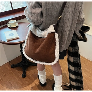 Détail du sac fourre-tout en daim marron avec bordure en polaire blanche et bandoulière
