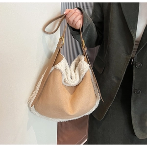 Détail du sac cabas en daim camel avec bordure en fourrure blanche et sangle en cuir