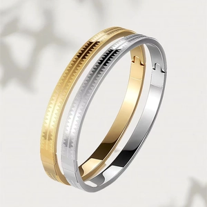 Detailed view of silver and gold bangles with engraved geometric triangle patterns