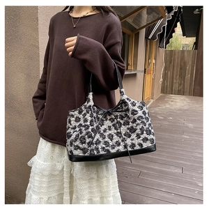 Leopard print plush tote bag featuring a decorative black bow and faux leather straps