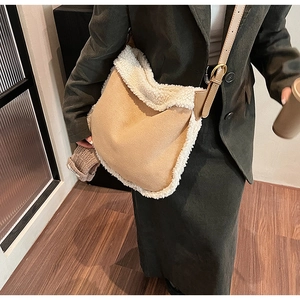 Détail d'un sac bandoulière en daim kaki avec bordure en fourrure blanche et sangle
