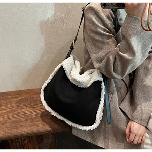 Modèle portant un sac Hobo en daim noir avec bordure en peau de mouton blanche et sangle