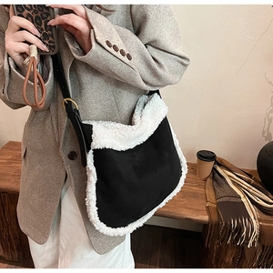 Détail du sac bandoulière en similicuir noir avec bordure en peluche blanche et boucle
