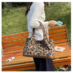 Detailed plush leopard print tote bag with brown leather handles and a bow detail