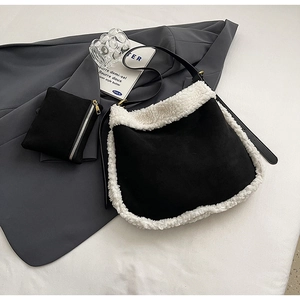 Détail du sac fourre-tout noir en daim avec bordure en peluche et petite pochette