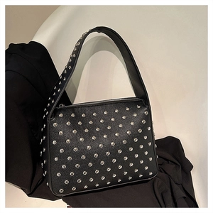 Detail of silver studs on black litchi grain leather shoulder bag with wide strap