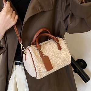 Weiße Teddy-Tasche im Boston-Stil mit braunem Lederbesatz, präsentiert von einem Model