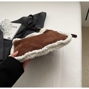 Détail de la texture du sac en daim marron avec bordure en fausse fourrure blanche