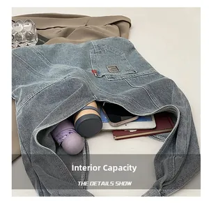 Vue détaillée de l'intérieur d'un grand sac fourre-tout en jean bleu avec divers objets