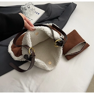 Détail du sac fourre-tout en daim marron vintage avec garniture en peluche et boucle dorée