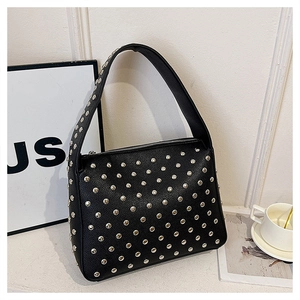 Close-up of black rivet handbag showing metallic stud details and textured PU leather finish