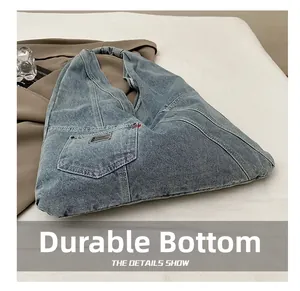 Détail du fond durable et des surpiqûres du sac cabas en jean avec poche frontale