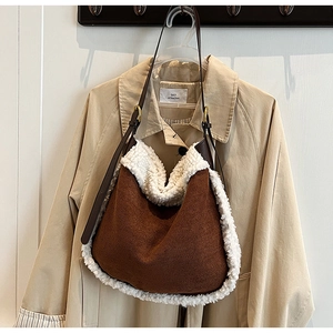 Détail du sac hobo en daim marron avec bordure en sherpa blanc et bandoulière en cuir
