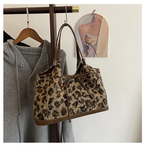 Detail of plush leopard print handbag with faux leather trim and delicate bow accent
