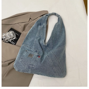 Détail d'un sac cabas en jean délavé montrant la poche avant et l'étiquette BDG
