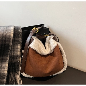 Détail du sac hobo en daim marron avec garniture en laine d'agneau et bandoulière
