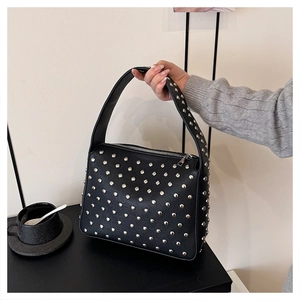 Close-up of black punk shoulder bag featuring detailed silver rivet studs and metal zipper