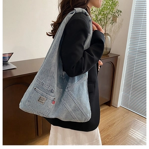 Détail du logo BDG sur le sac fourre-tout en denim délavé bleu clair et étiquette rouge