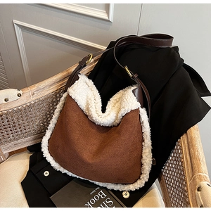 Détail du sac seau en suédine marron avec bordure en fausse fourrure blanche et or